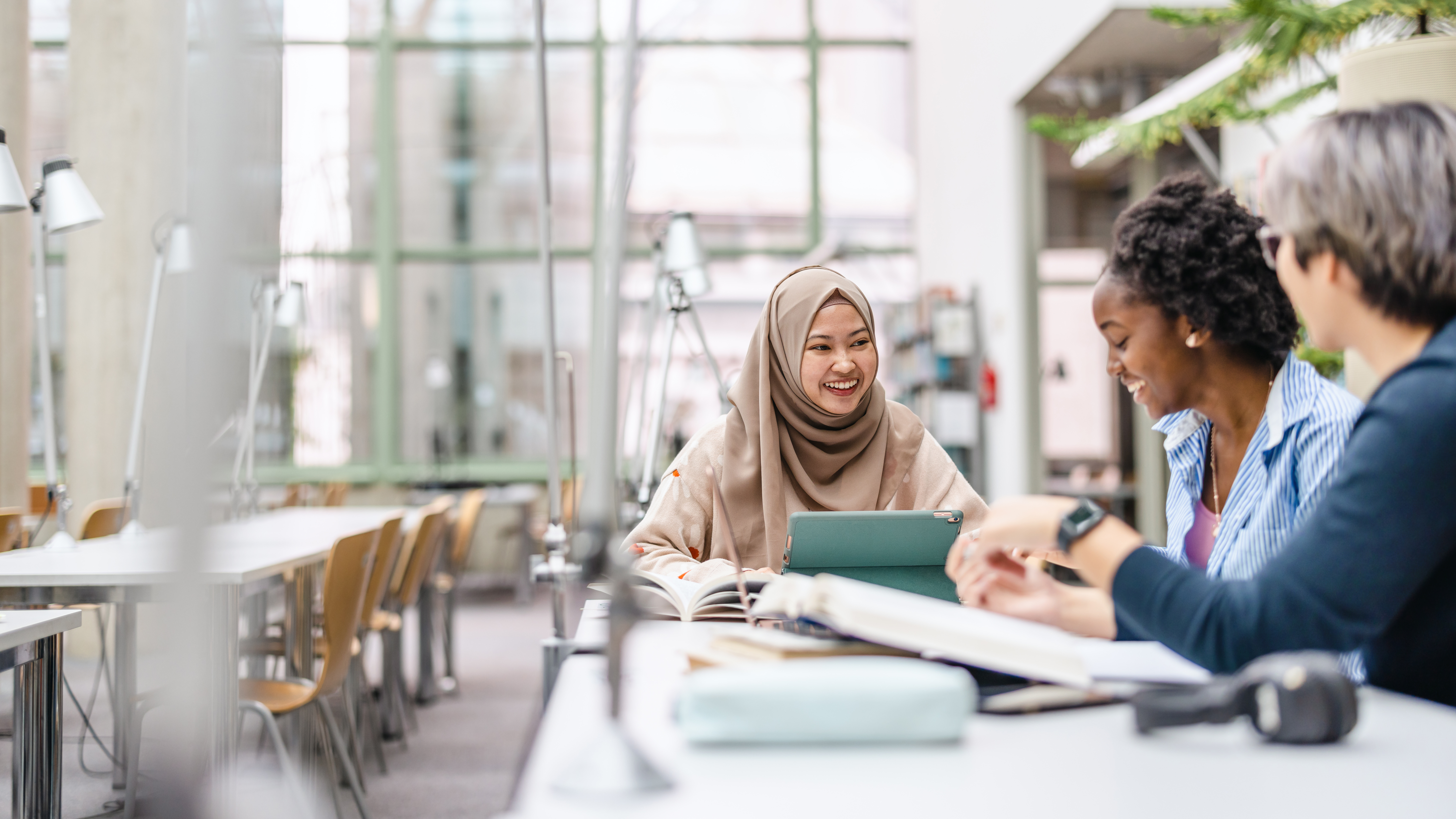 Multiethnic group of students sitting in a library and studying together