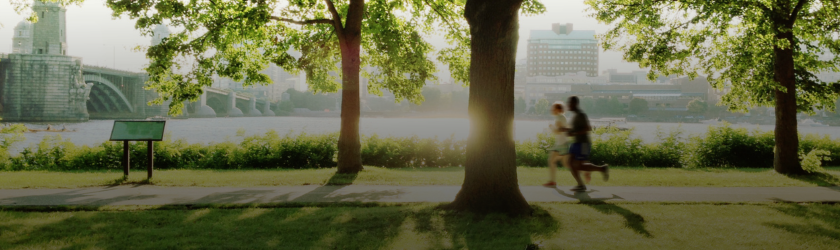 Banner image of couple jogging through the park.